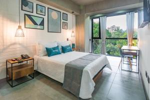 a bedroom with a bed and a window and a desk at Loft 32 Medellín Living in Medellín