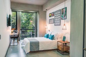 a bedroom with a bed and a large window at Ayenda Loft 32 in Medellín