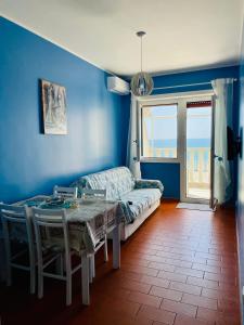um quarto azul com uma mesa e um sofá em T-Village502 em Anzio