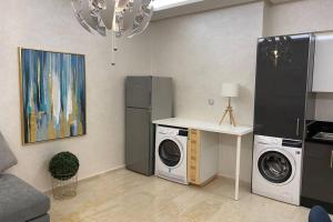 uma cozinha com máquina de lavar e secar roupa num quarto em Du Haut Standing au coeur du Parc et Plage à 180 m em Mohammedia