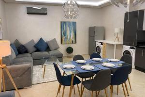 sala de estar con mesa azul y sillas en Du Haut Standing au coeur du Parc et Plage à 180 m, en Mohammedia