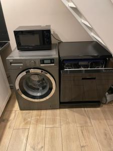 ミエンジズドロイェにあるApart Promenada Gwiazdの洗濯機と乾燥機が備わります。