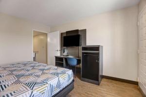 a bedroom with a bed and a desk with a computer at Motel 6-Amarillo, TX - Airport in Amarillo