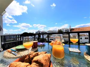 een tafel met brood en glazen sinaasappelsap bij ALTIUM Cabanas in Cabanas de Tavira
