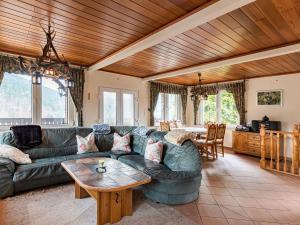 a living room with a green couch and a table at Majestic Holiday Home in Untersch nau with Jacuzzi in Unterschönau