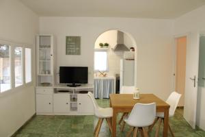 a dining room with a table and white chairs at Casa frente al lago in La Savina