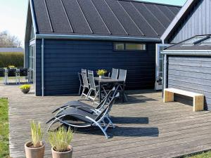 12 person holiday home in Hadsund في Nørre Hurup: فناء على طاولة وكراسي على السطح