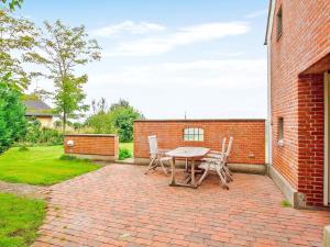 a brick patio with a table and chairs on it at 6 person holiday home in Fars in Hvalpsund