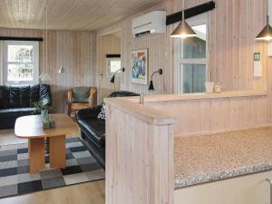 ein Wohnzimmer mit einem Sofa und einem Tisch in der Unterkunft Holiday home Hadsund XX in Nørre Hurup
