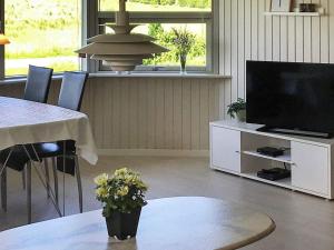 a living room with a television and a table with chairs at Two-Bedroom Holiday home in Aabenraa 2 in Aabenraa