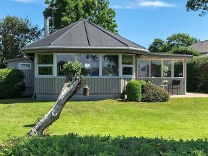 a house with a tree branch in the yard at Two-Bedroom Holiday home in Aabenraa 2 in Aabenraa