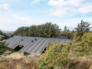 a house on the beach with a metal roof at 10 person holiday home in L kken in Løkken