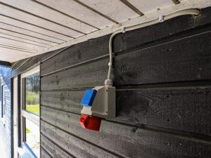 un outil suspendu sur le côté d'une maison dans l'établissement 8 person holiday home in Hals, à Øster Melholt