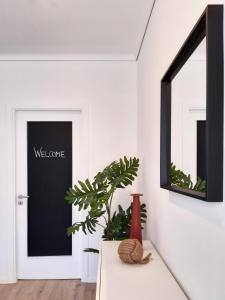 a hallway with a black and white door and a mirror at PAPPA casa vacanze in Marina di Ragusa