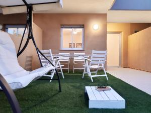 a room with a table and chairs on the grass at PAPPA casa vacanze in Marina di Ragusa