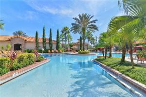 a swimming pool in a resort with palm trees at COZY RESORT CONDO NEAR TOP ATTRACTIONS IN ORLANDO in Kissimmee