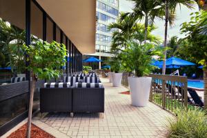 una fila de sillas y árboles frente a un edificio en Holiday Inn Miami West - Airport Area, an IHG Hotel, en Hialeah Gardens