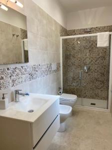 een badkamer met een wastafel, een toilet en een douche bij Villa Cinque in Vico Equense