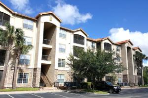 un bâtiment avec une voiture garée devant dans l'établissement COZY RESORT CONDO NEAR TOP ATTRACTIONS IN ORLANDO, à Kissimmee