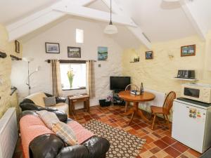 a living room with a couch and a table at Ffynnon Tom in Trevine