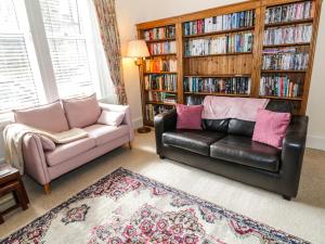 sala de estar con sofá y estante para libros en 6 Ronald Place en Stirling
