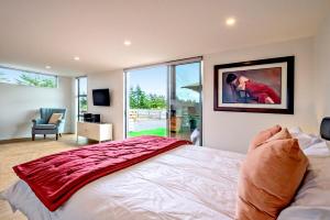 a bedroom with a bed and a large window at Farm Retreat B&B in West Melton