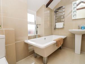 a bathroom with a bath tub and a sink at Forge Cottage in Sennen +16 photos