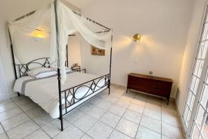 a bedroom with a canopy bed and a wooden dresser at Rose d'Antibes in Antibes