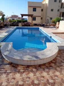 ein großer Swimmingpool in einem Innenhof in der Unterkunft First floor chalet 4 VILLA 114 2bed rooms and 2 bathrooms Green Beach in El-Alamein