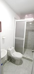 Un baño blanco con inodoro y ducha. en apartaestudio J.V.G., en San Andrés 24 fotos más