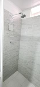 Un baño con ducha con puerta de cristal. en apartaestudio J.V.G., en San Andrés