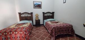 um quarto com duas camas e um candeeiro em Hotel Posada Santa Teresita em Antigua Guatemala