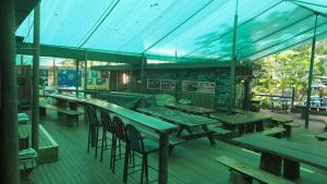 an empty restaurant with wooden tables and chairs at Daintree Crocodylus in Cow Bay