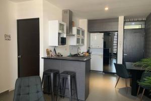 una cucina con un bancone e sgabelli in una stanza di Departamento en Edificio El Semillero a Monterrey