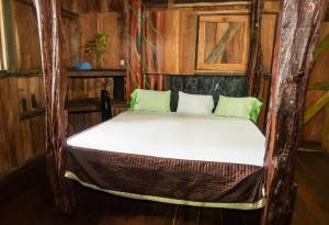 a bed in a room with wooden walls at Mirador Prendas in Sarapiquí +109 photos