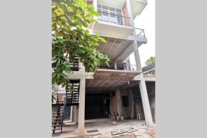 a tall building with a balcony and a tree at Panadura Top view - ACCEDE Apartment in Panadura