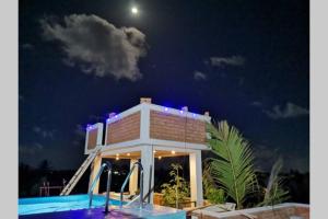 a house with a swimming pool at night at Panadura Top view - ACCEDE Apartment in Panadura