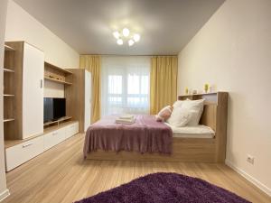 a bedroom with a bed with a tv and a window at Right Room на улице 65 лет Победы in Kaluga