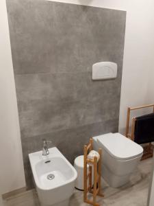 a bathroom with a white toilet and a sink at B&B CaselloA Suites in Siracusa