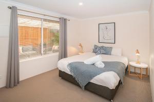 a bedroom with a large bed and a window at Central Townhouse Margaret River in Margaret River Town
