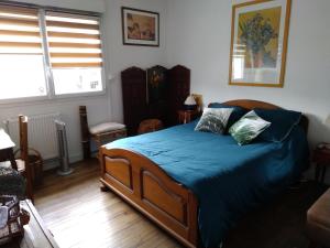 a bedroom with a large bed with blue sheets and pillows at Chambre César B&B- au 1er - Villa Chaumonty in Périgueux