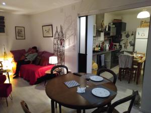 uma sala de estar com uma mesa e um homem sentado num sofá em Chambre César- au 1er - Villa Chaumonty em Périgueux