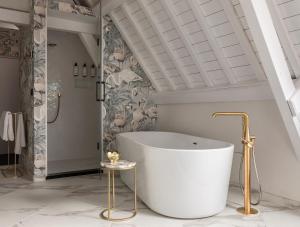 a bath tub in a bathroom with a ceiling at Poorter Boutique Hotel Brielle in Brielle