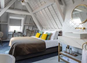 a bedroom with a bed with a mirror and a sink at Poorter Boutique Hotel Brielle in Brielle