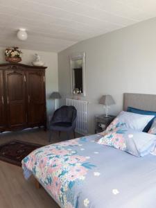 a bedroom with a bed and a chair at Gite 2 personnes in Plonévez-Porzay