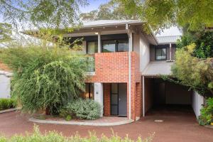 a red brick house with a driveway and trees at Apartment 36 in Margaret River Town