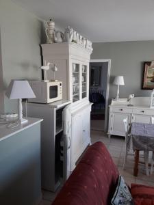 a kitchen with a white cabinet with a microwave at Gite 2 personnes in Plonévez-Porzay +6 photos