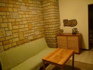 a room with a couch and a table and a brick wall at Ośrodek Wypoczynkowy W sosnowym lesie in Międzywodzie