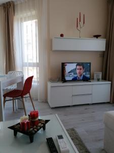 a living room with a flat screen tv on a white cabinet at By the Waves luxury beach apartment in Varna City