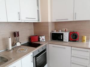 A kitchen or kitchenette at By the Waves luxury beach apartment